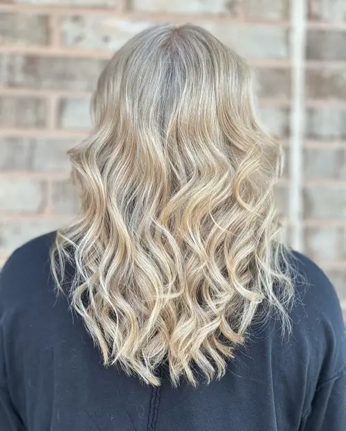 Golden blonde highlights with beachy waves on mid-length hair by an Ash and Ivy Salon colorist