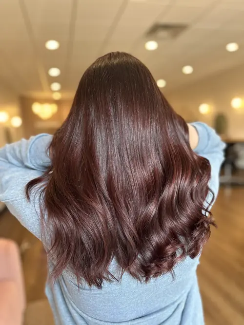 Rich auburn red-brown gloss on long wavy hair, an organic colour service at Ash and Ivy Salon