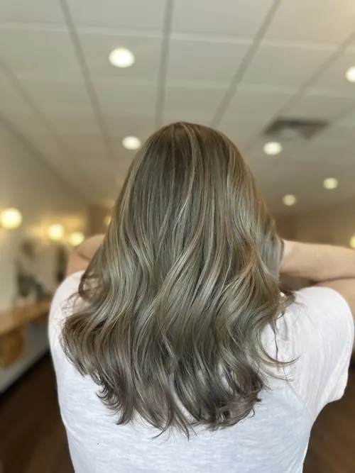 Mushroom blonde on a layered mid-length cut with soft movement, styled at Ash and Ivy Salon