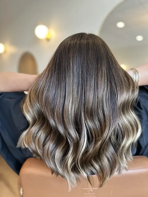 Brunette lob with icy blonde face-framing highlights and beach waves at Ash and Ivy Salon, Evans GA